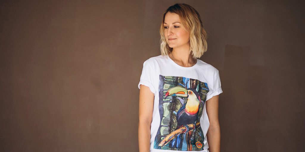 Mulher loira vestindo uma camiseta de manga curta branca com estampa