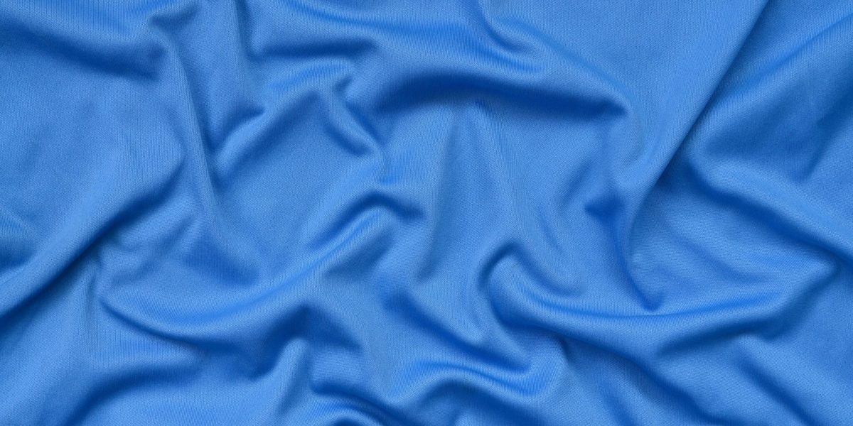 Detailed polyester blue fabric texture with many long folds